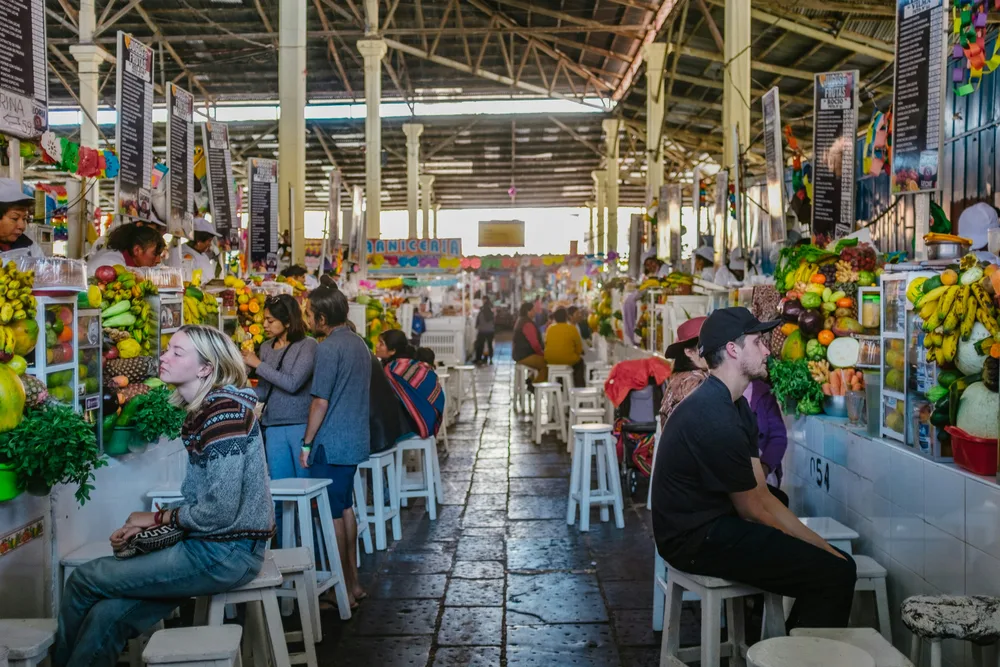Comensales y puestos de comida en el interior del Mercado San Pedro de Cusco
